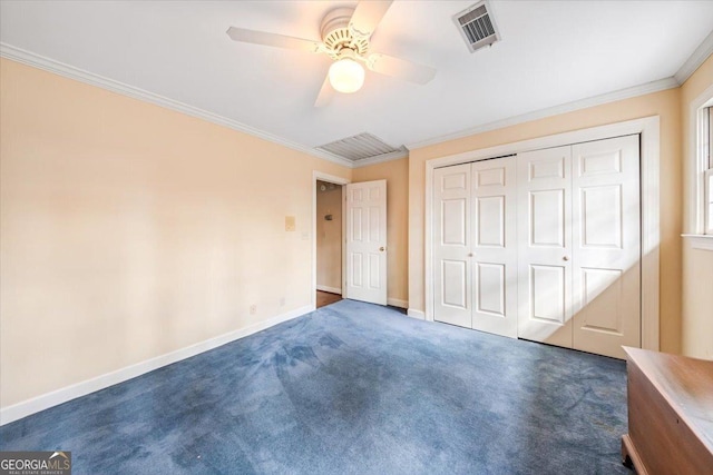 unfurnished bedroom with crown molding, ceiling fan, dark carpet, and a closet