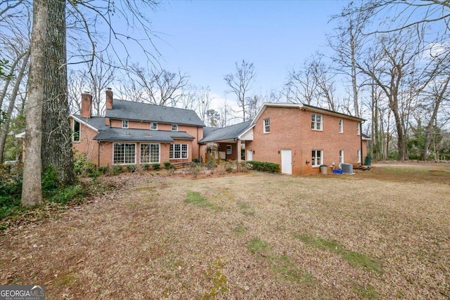 rear view of property featuring a yard and central AC unit