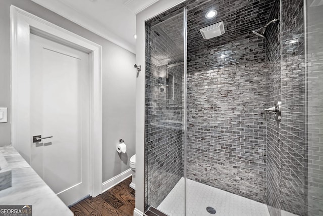 bathroom with hardwood / wood-style flooring, walk in shower, ornamental molding, and toilet