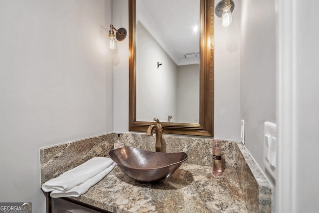 bathroom featuring crown molding and vanity