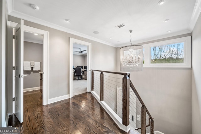 hallway with an inviting chandelier, crown molding, and dark wood-type flooring