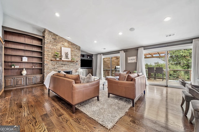 living room with vaulted ceiling, dark wood-type flooring, and a fireplace