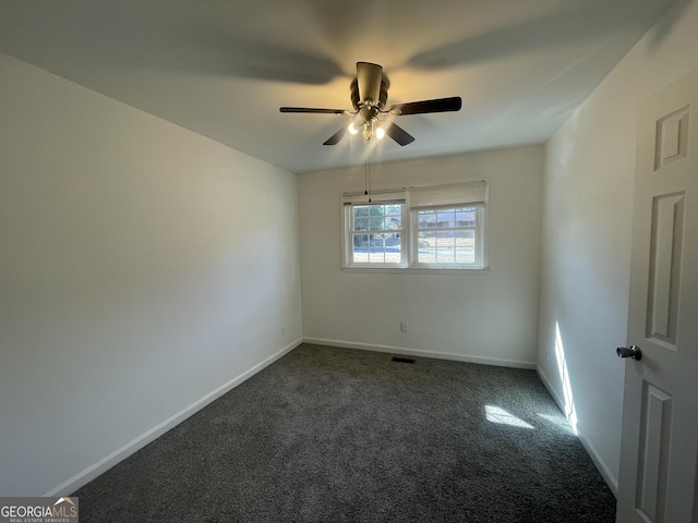 spare room featuring ceiling fan and dark colored carpet