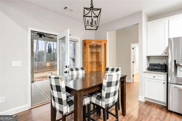 dining room with visible vents, baseboards, and wood finished floors