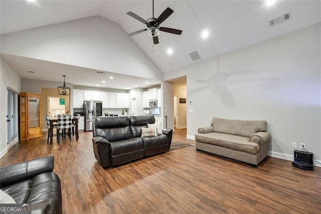 living area with visible vents, dark wood-type flooring, a ceiling fan, high vaulted ceiling, and baseboards