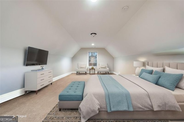 carpeted bedroom featuring lofted ceiling and baseboards