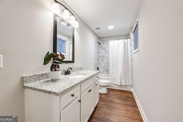 bathroom featuring baseboards, toilet, shower / tub combo with curtain, wood finished floors, and vanity