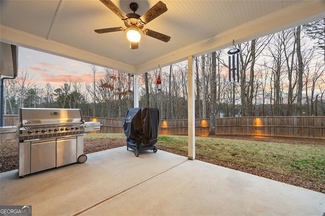 view of patio / terrace with a grill, fence, ceiling fan, and exterior kitchen