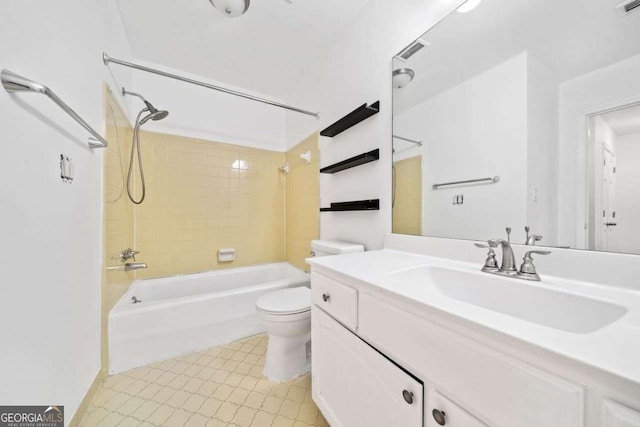 full bathroom featuring tiled shower / bath combo, vanity, and toilet