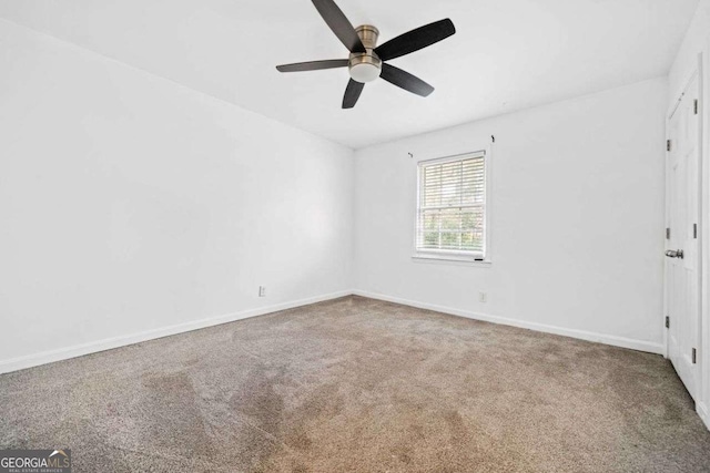 spare room with ceiling fan and carpet