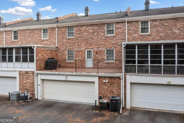 back of house with central AC and a garage