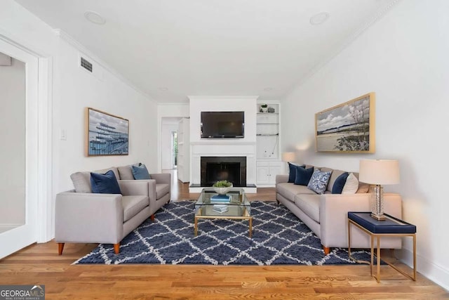 living room featuring ornamental molding and wood-type flooring