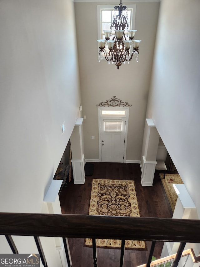 entrance foyer with dark hardwood / wood-style flooring and a notable chandelier