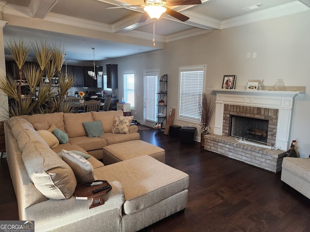 living room featuring ornamental molding, dark wood-type flooring, a brick fireplace, and beam ceiling