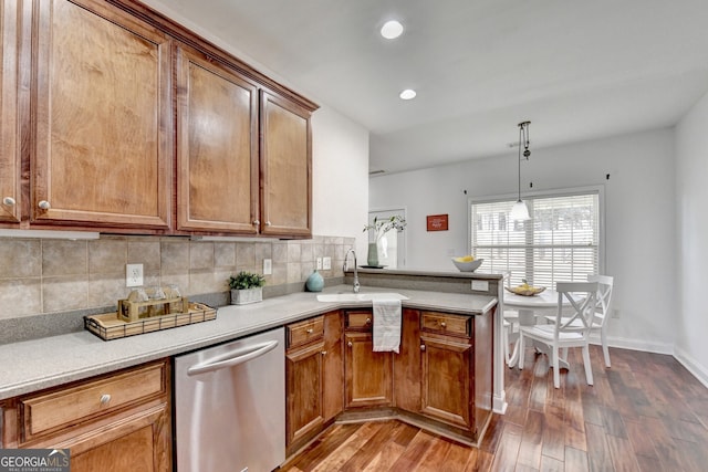 kitchen with decorative light fixtures, tasteful backsplash, sink, dark hardwood / wood-style flooring, and stainless steel dishwasher