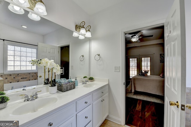 bathroom with ceiling fan, plenty of natural light, a bathtub, and vanity