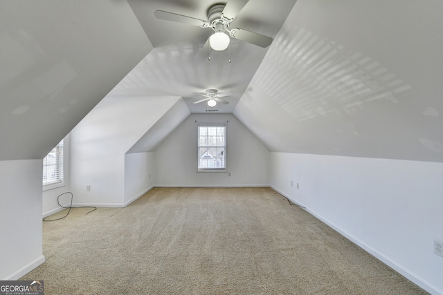 additional living space with vaulted ceiling, light colored carpet, and ceiling fan