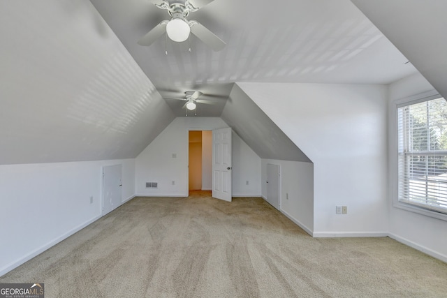 additional living space featuring light carpet, vaulted ceiling, and ceiling fan