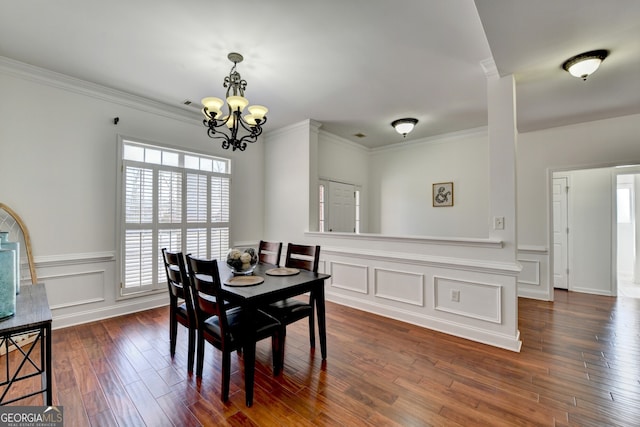 dining area with a notable chandelier, crown molding, and dark wood-type flooring