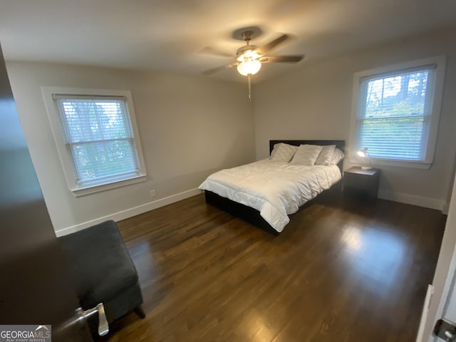 bedroom with dark hardwood / wood-style floors and ceiling fan