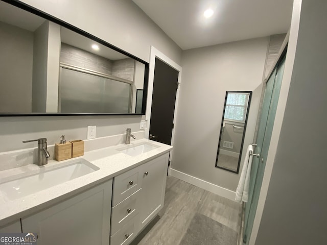 bathroom featuring vanity, hardwood / wood-style flooring, and a shower with shower door