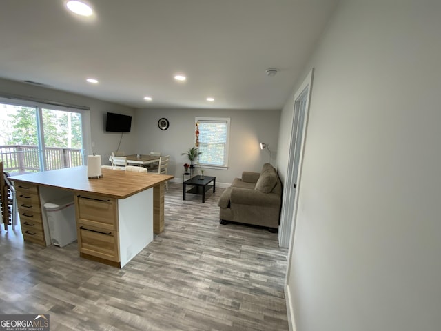 kitchen with a healthy amount of sunlight, a center island, light brown cabinetry, and light wood-type flooring