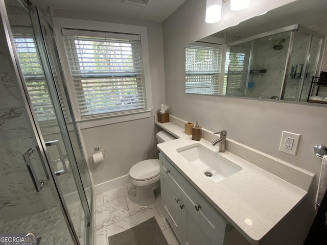 bathroom with vanity, a shower with shower door, toilet, and a healthy amount of sunlight