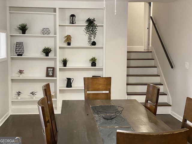 dining room featuring dark hardwood / wood-style flooring and built in shelves