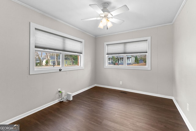 spare room with dark wood-type flooring, ceiling fan, and crown molding