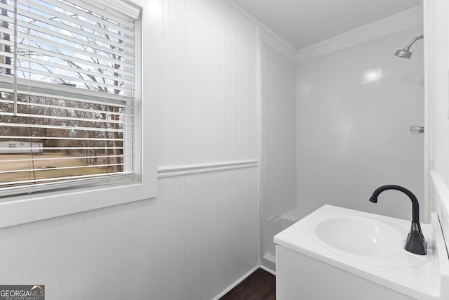 bathroom featuring walk in shower, ornamental molding, and vanity