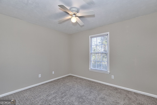 spare room featuring ceiling fan, a textured ceiling, and carpet