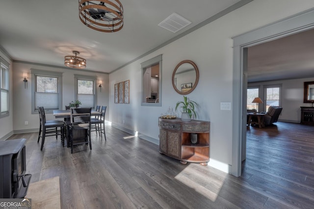 dining room with ornamental molding and dark hardwood / wood-style floors