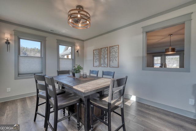 dining area featuring crown molding, a healthy amount of sunlight, and wood-type flooring