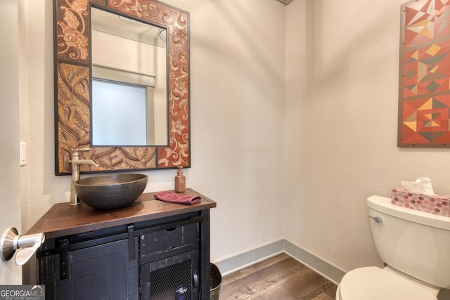 bathroom with hardwood / wood-style flooring, vanity, and toilet