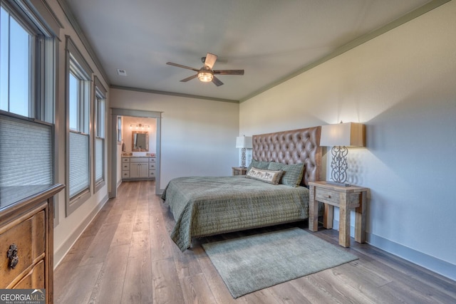 bedroom featuring ornamental molding, connected bathroom, ceiling fan, and light wood-type flooring