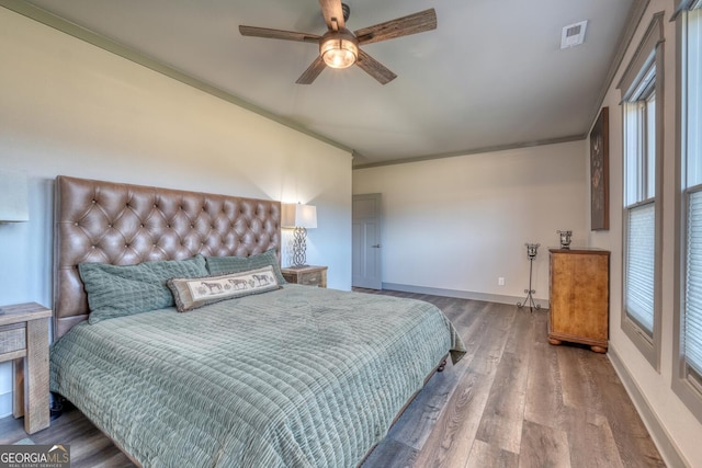 bedroom with ceiling fan, ornamental molding, and wood-type flooring