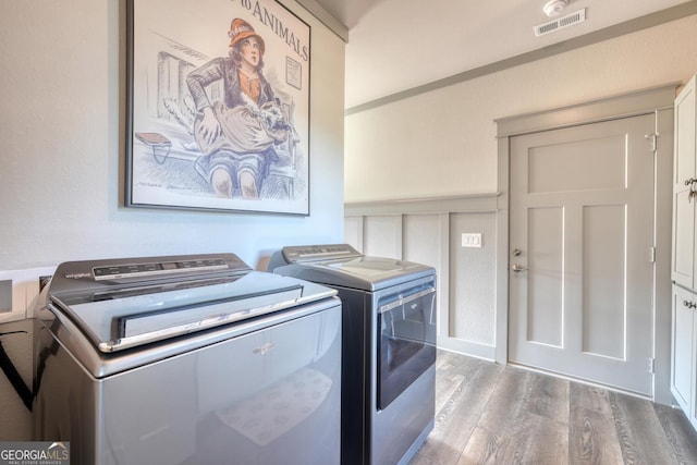 washroom with hardwood / wood-style floors and washing machine and dryer