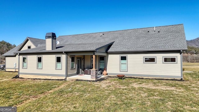 rear view of house featuring a patio area and a lawn