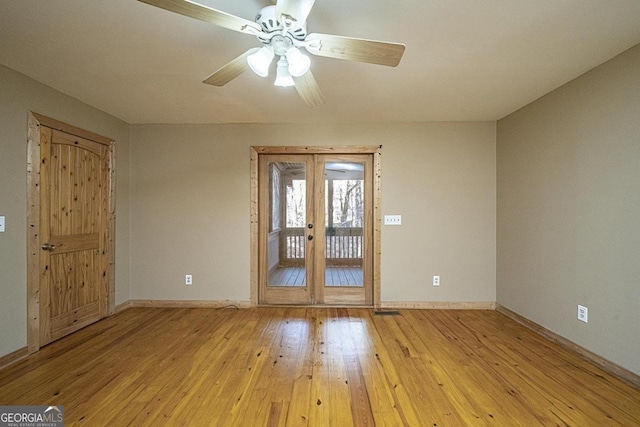 empty room featuring french doors, ceiling fan, and light hardwood / wood-style flooring