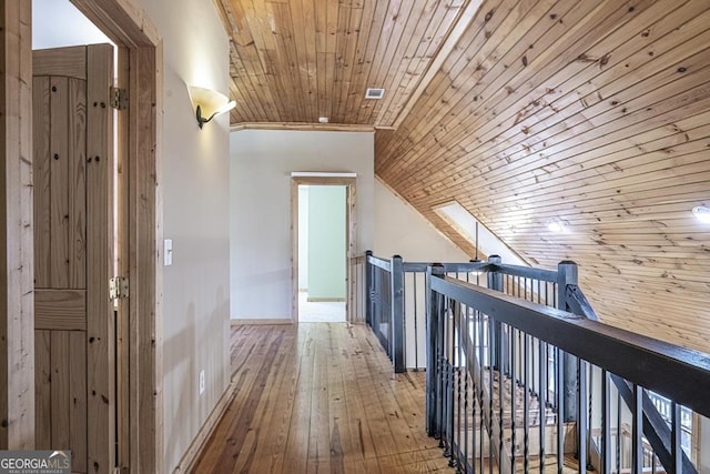 hallway featuring wood-type flooring, ornamental molding, and wooden ceiling