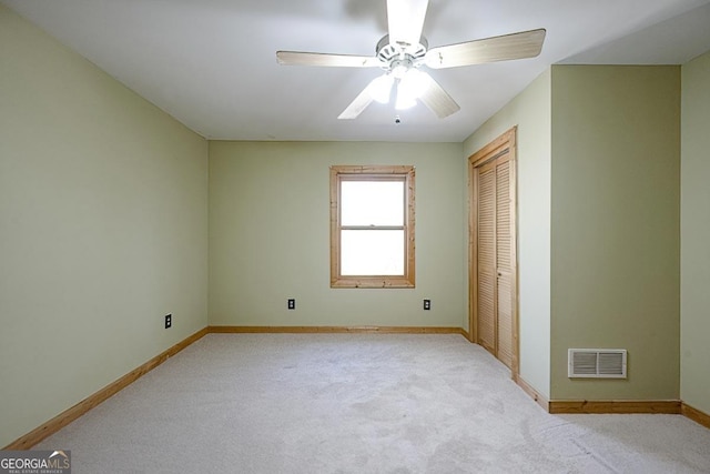 empty room with light colored carpet and ceiling fan