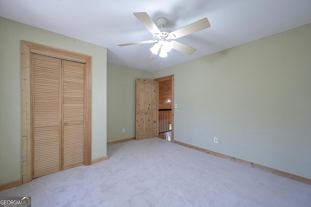 unfurnished bedroom featuring light carpet, ceiling fan, and a closet