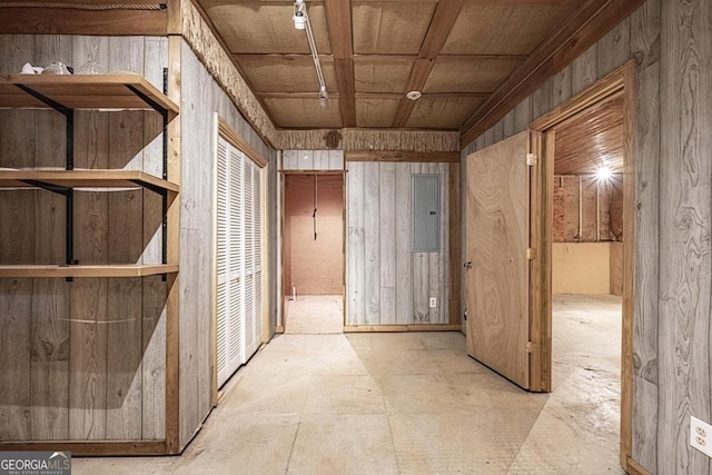 hallway with wooden ceiling, electric panel, and wood walls