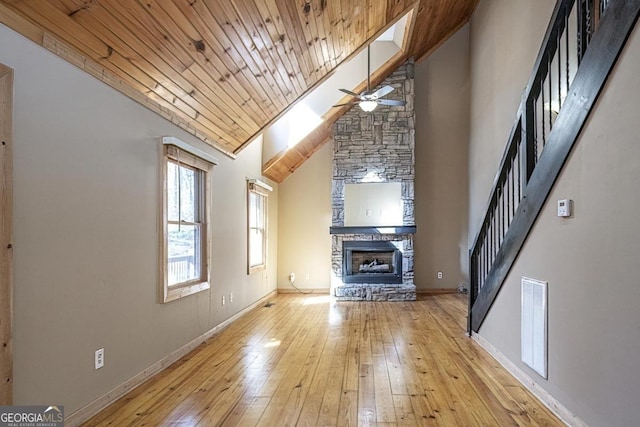 unfurnished living room with light hardwood / wood-style flooring, ceiling fan, high vaulted ceiling, a fireplace, and wooden ceiling