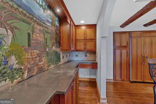 kitchen featuring dark hardwood / wood-style flooring, backsplash, and beamed ceiling