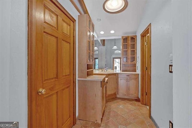 corridor featuring sink and light tile patterned floors