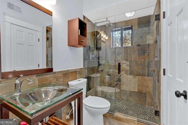 bathroom with sink, tile walls, an enclosed shower, and toilet