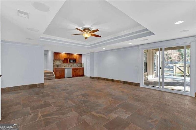 unfurnished living room with crown molding, a tray ceiling, and ceiling fan