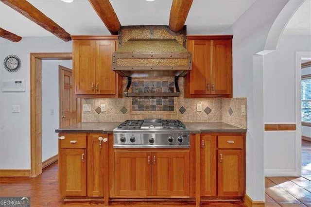 kitchen with tasteful backsplash, beam ceiling, stainless steel gas cooktop, and light wood-type flooring