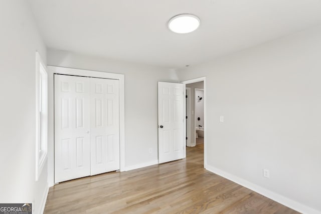 unfurnished bedroom featuring light hardwood / wood-style floors and a closet